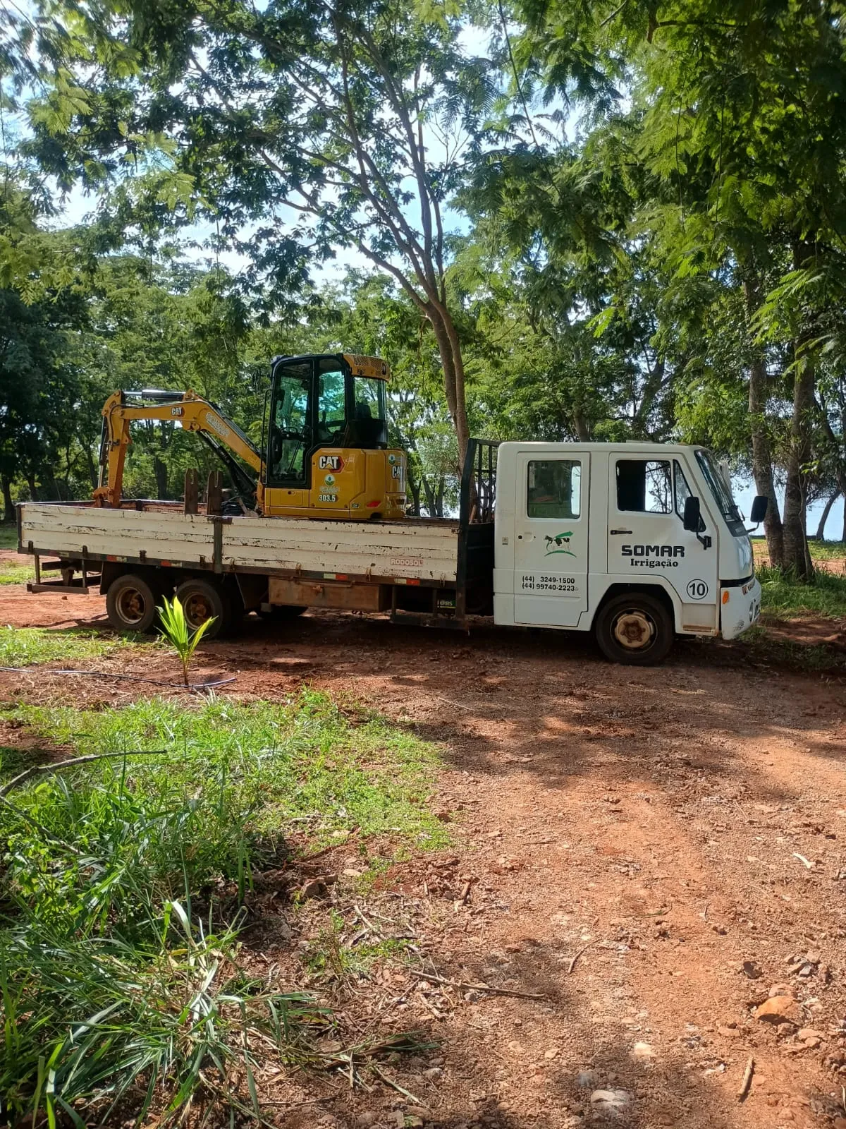 Caminhão da Somar transportando equipamento em área de obra