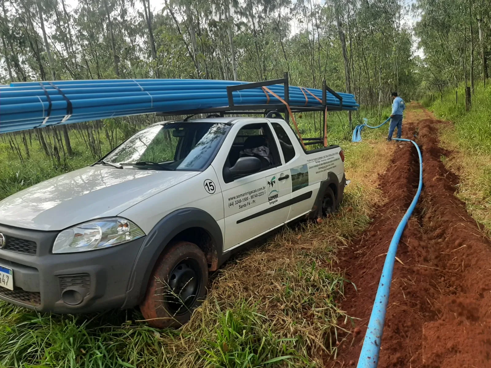 Caminhonete da Somar transportando tubos ao lado de uma valeta