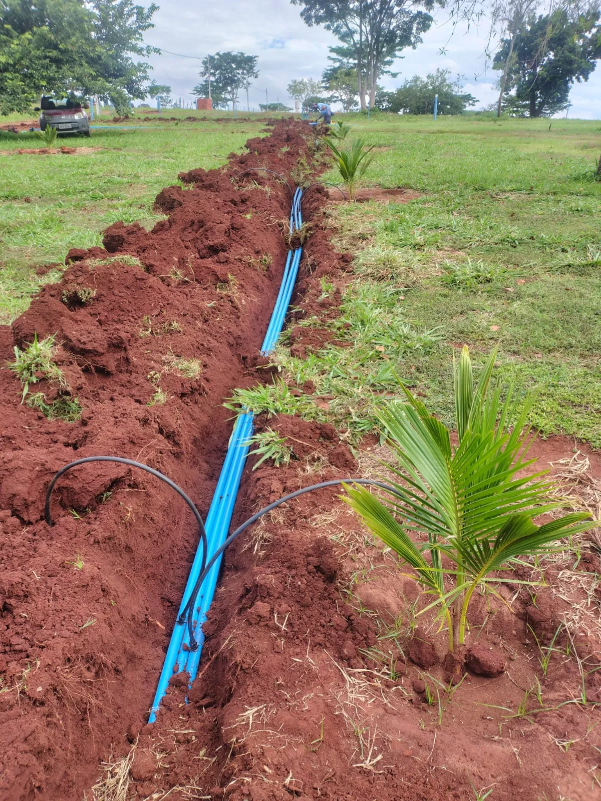 Tubulação azul instalada em valeta aberta no campo